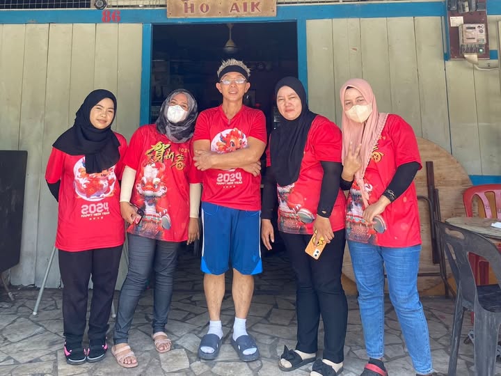 The owner of Ho Aik, centre, with four team members outside the shop